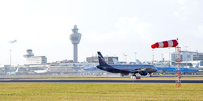 Foto van luchthaven Schiphol met op de achtergrond de verkeerstoren.